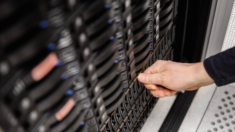IT Engineer Installing Server Drive In San at Datacenter Cropped hand of male IT engineer installing server drive in SAN at datacenter