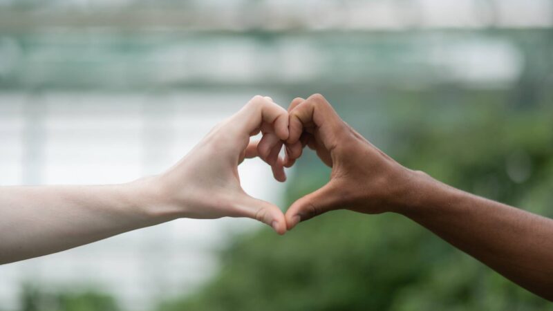 Men with different nationality making heart out of hands Close up of two men with different nationality making heart out of hands